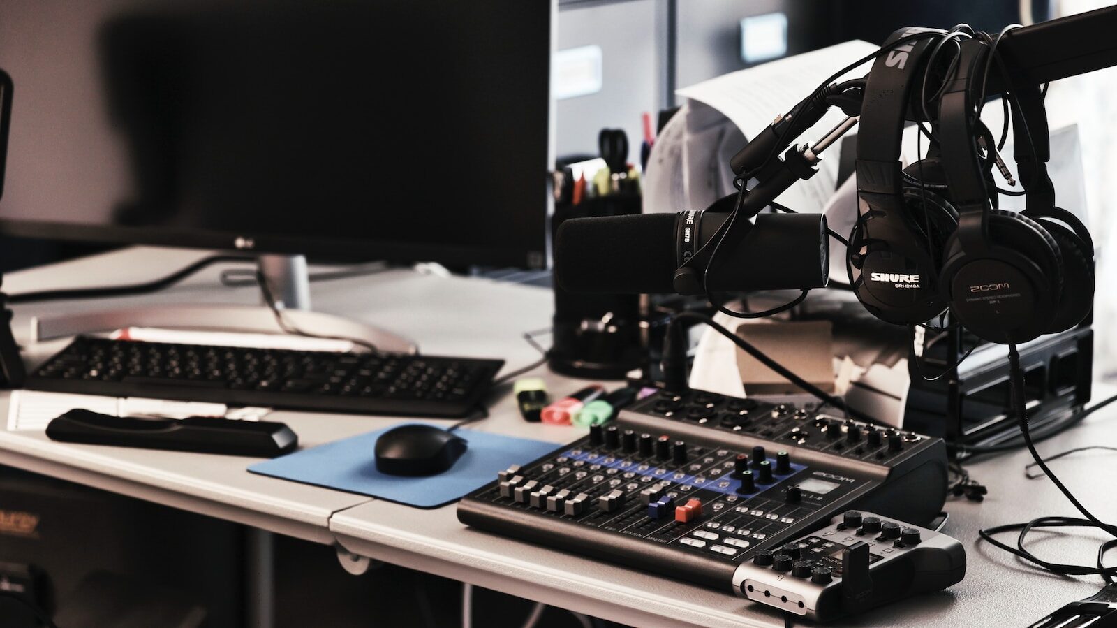 a computer desk with a microphone and headphones on it